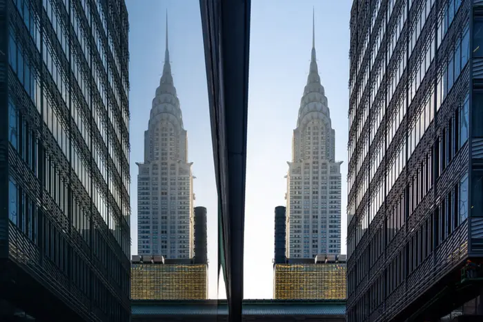 The Chrysler building seen twice due to a reflection in a glass wall.